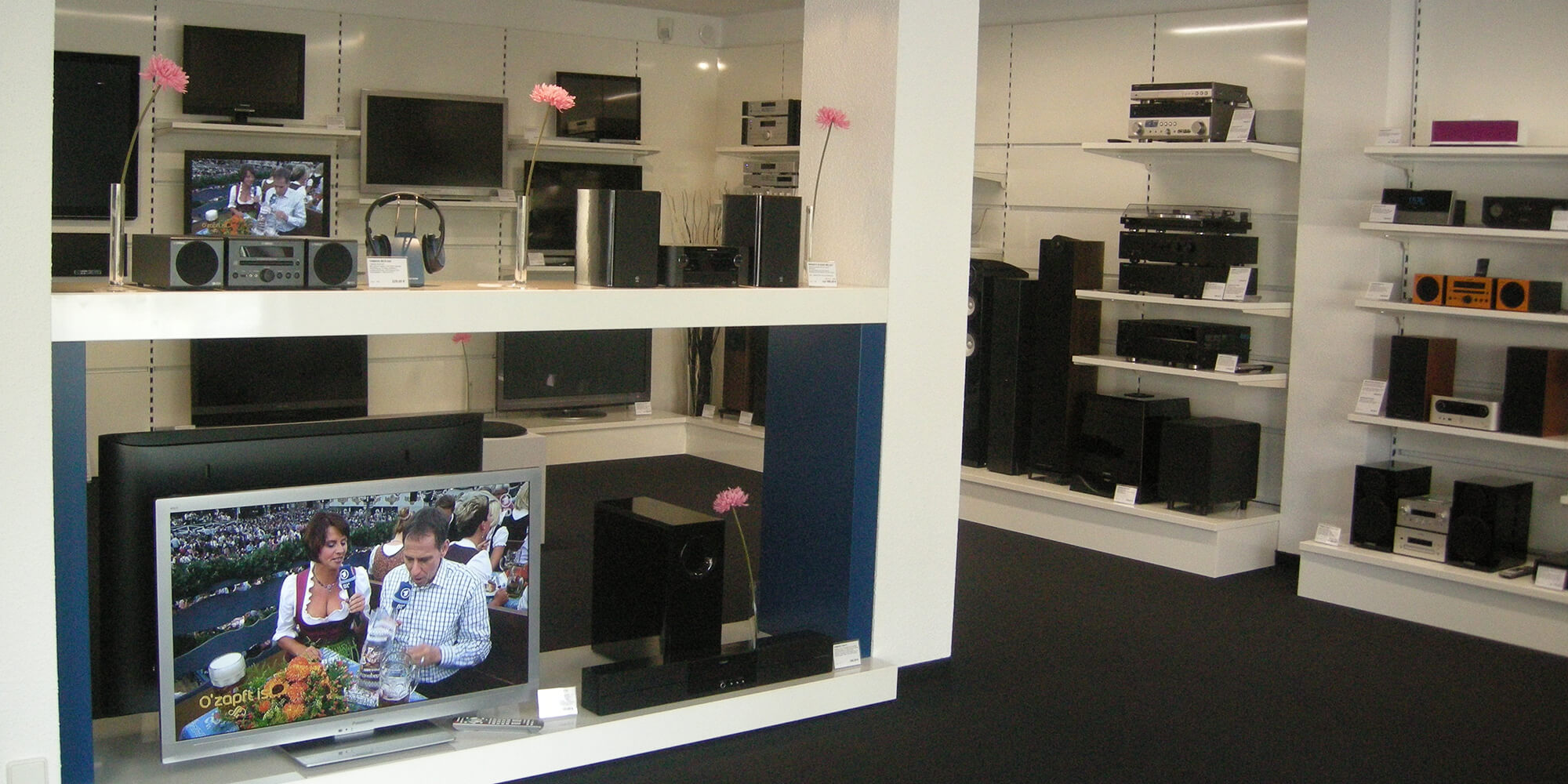 Innenansicht von unserem Elektronikgeschäfts mit mehreren Fernsehern, Stereoanlagen und Lautsprechern.