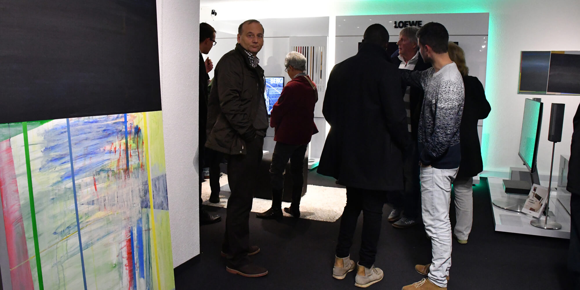 Menschen in unserem Fachgeschäft mit Technik und Kunst, einige im Gespräch.